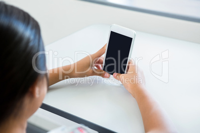 Cropped image of girl using mobile phone