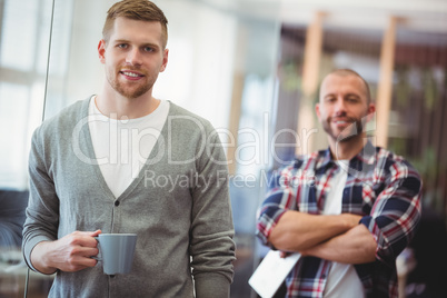 Portrait of businessman holding coffee cup at creative office
