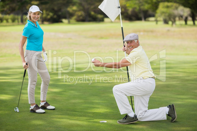 Portrait of couple while man holding golf ball