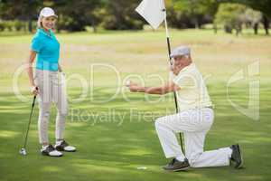 Portrait of couple while man holding golf ball