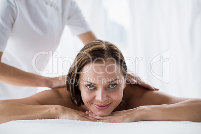 Portrait of smiling woman receiving back massage