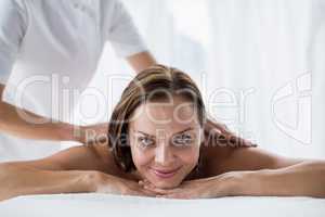 Portrait of smiling woman receiving back massage