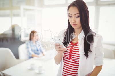 Young businesswoman using mobile phone at creative office