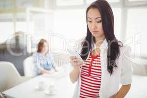 Young businesswoman using mobile phone at creative office
