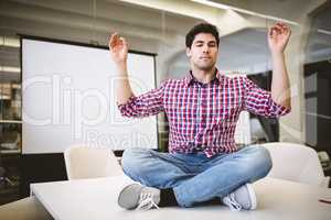 Businessman performing yoga in meeting room