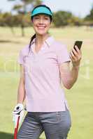 Portrait of smiling golfer woman using phone