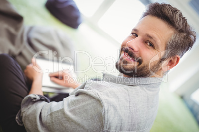 Businessman holding digital tablet in creative office