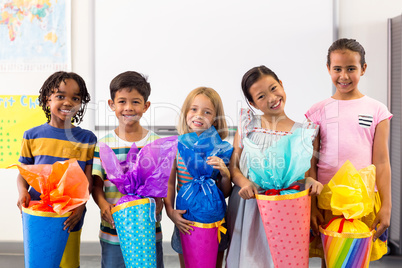 Smiling multi ethnic children holding artwork