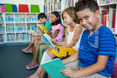 Elementary students reading books in library