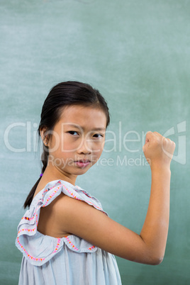 Portrait of girl showing fist in classroom