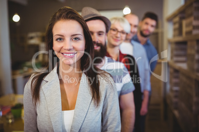 Confident businesswoman with colleagues standing in row