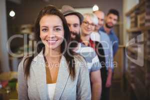 Confident businesswoman with colleagues standing in row