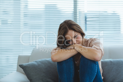 Sad woman sitting on sofa