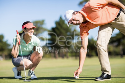 Portrait of man removing golf ball from hole