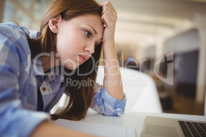 Stressed businesswoman with head in hand in office