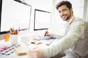 Portrait of businessman working at desk in office