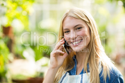 Young woman using cellphone at greenhouse