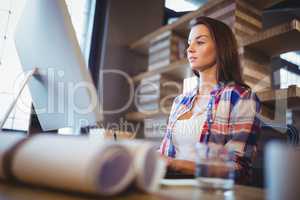 Businesswoman working on computer in creative office
