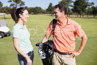 Smart smiling golfer couple