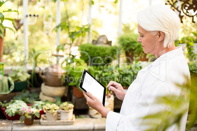 Scientist using tablet computer at greenhouse