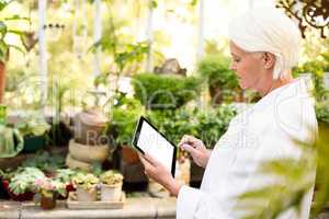 Scientist using tablet computer at greenhouse