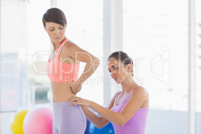 Trainer assisting young woman