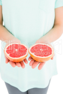 Woman holding grapefruit slices Woman holding grapefruit slices