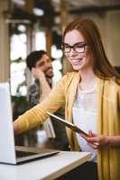 Businesswoman using laptop with male coworker