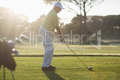 Full length side view of mature man playing golf