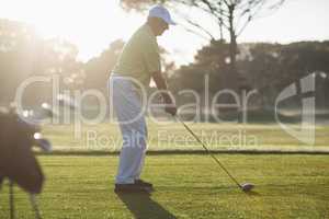 Full length side view of mature man playing golf
