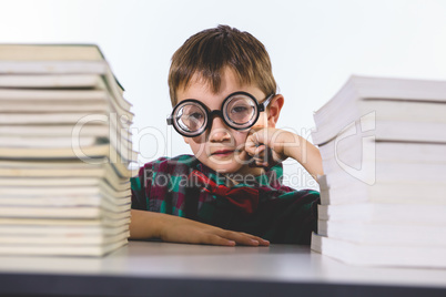 Portrait of boy with books on table in classroom