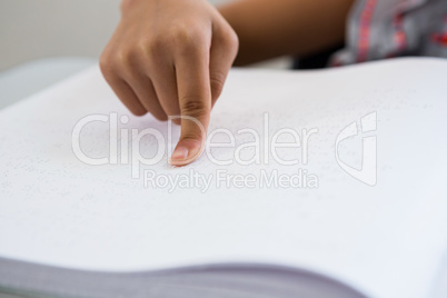 Cropped image of child reading braille book