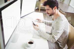 Businessman using mobile phone at desk