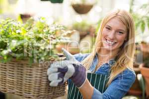 Young gardener holding plants in wicker basket