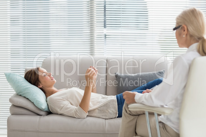 Woman talking to therapist while lying on sofa