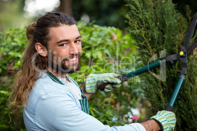 Portrait of confident gardener with hedge clippers at garden