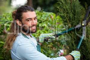 Portrait of confident gardener with hedge clippers at garden