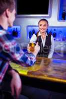 Smiling bartender serving beer to man