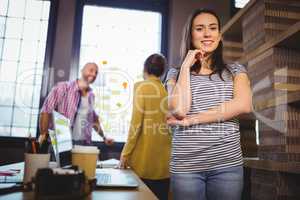 Confident businesswoman with coworkers in background