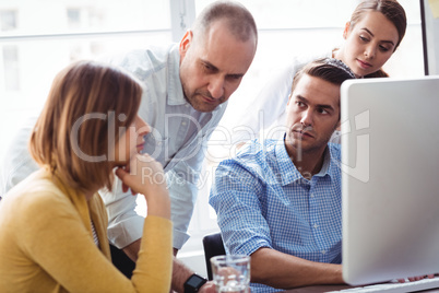 Business people looking at thoughtful coworker