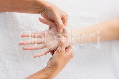 Cropped image of masseur massaging woman hand