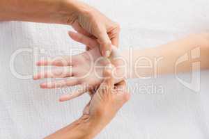 Cropped image of masseur massaging woman hand