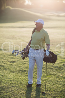 Full length of mature man carrying golf bag