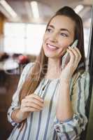Close-up of businesswoman smiling while using mobile phone in of