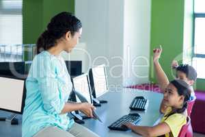 Teacher looking at children raising hands