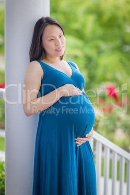 Portrait of Young Pregnant Chinese Woman on the Front Porch