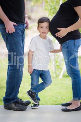 Young Son With Ear on Pregnant Belly of Mommy Outdoors