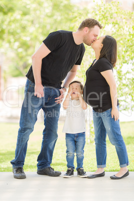 Young Son Covers His Eyes as Pregnant Mommy and Daddy Kiss