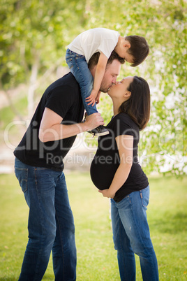 Pregnant Mixed Race Couple Kissing with Young Son Riding Piggyba