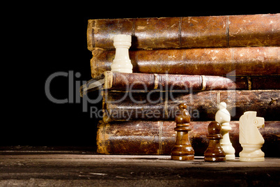 Old books and chess pieces